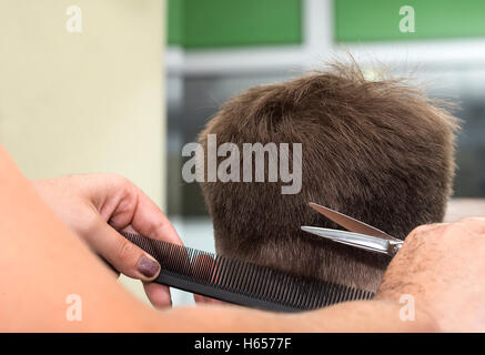 Al parrucchiere di ottenere un nuovo taglio di capelli maschile. Foto Stock