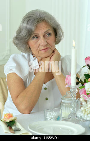 Donna anziana sul tavolo Foto Stock