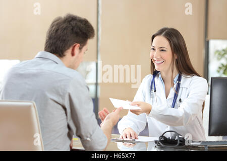 Felice femmina medico dando una prescrizione per il suo paziente in una consultazione Foto Stock
