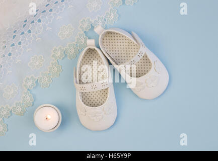 Coppia di bianco baby babbucce su sfondo blu con Abito in pizzo Foto Stock