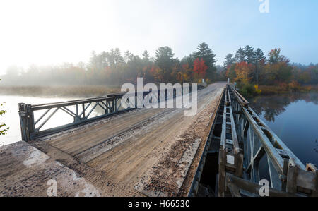Ottobre Mattino sole splende su una singola corsia di acciaio e legno ponte sopra il lago di Corry. Foto Stock