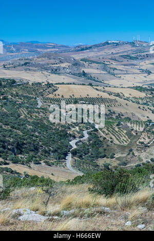 Paesaggi della Sicilia centrale in estate. Con la tipica siciliana di colline e ulivi, con una strada che si snoda attraverso la moun Foto Stock