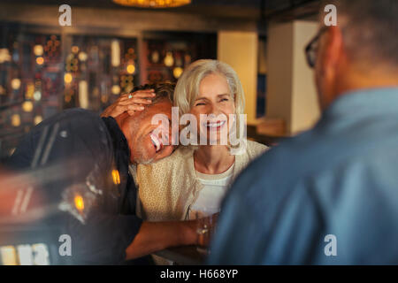 Affettuosa coppia senior di ridere e abbracciando in bar Foto Stock