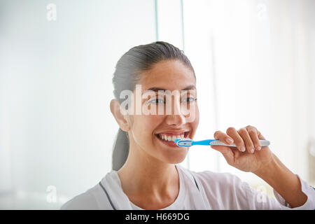 Donna spazzolare i denti con spazzolino da denti Foto Stock