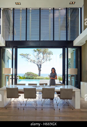 Imprenditrice lavora al tavolo da pranzo nella casa di lusso vetrina interno Foto Stock