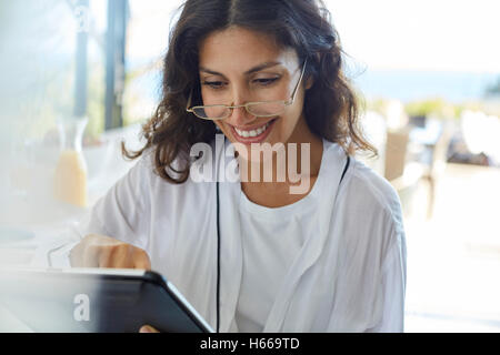 Donna sorridente in accappatoio con tavoletta digitale Foto Stock