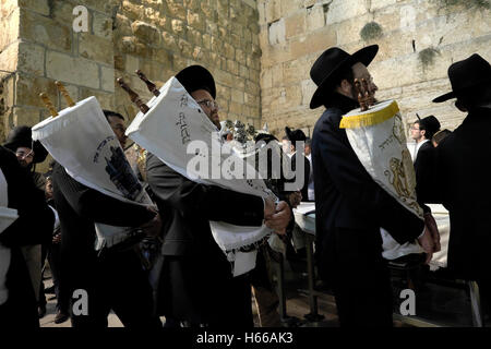 Gerusalemme, Israele. 24 ott 2016 Gli Ebrei religiosi ballando con cartigli di Torah come si celebra il Simchat Torah una festa ebraica che celebra e segna la conclusione del ciclo annuale di Torah pubbliche letture, e l inizio di un nuovo ciclo nella parete occidentale della città vecchia di Gerusalemme Est Israele Foto Stock