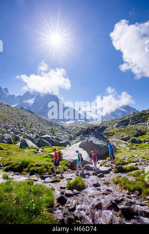 Gli escursionisti che attraversa un flusso sulla Grand Balcon Nord, Valle di Chamonix, sulle Alpi francesi, Francia. Foto Stock