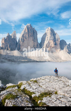 Escursionista e nube del mattino sotto le Tre Cime di Lavaredo. Dolomiti di Sesto, Alto Adige, Italia. Foto Stock