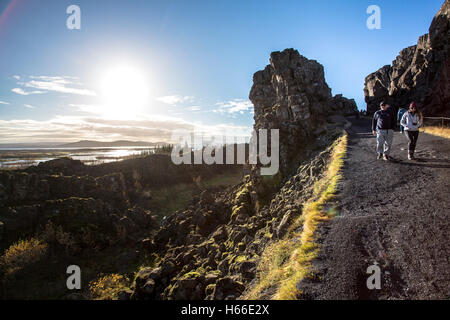 Turisti che visitano la rift Valley nel Parco nazionale di Pingvellir, sede dell'antico parlimento islandese in Islanda, camminando attraverso la gola. Foto Stock