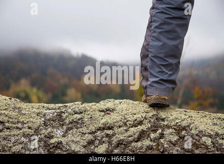 Escursionista gamba outdoor in piedi sul picco di montagna Foto Stock