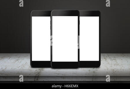 Tre telefoni cellulari sulla tavola con display isolato per mockup. Mobile app o una pagina web di presentazione. Foto Stock