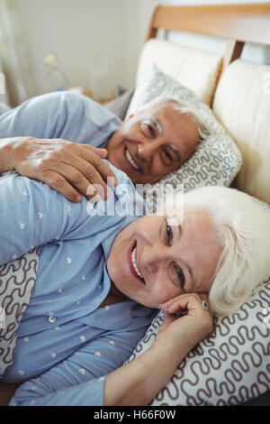 Felice coppia senior giacente sul letto Foto Stock