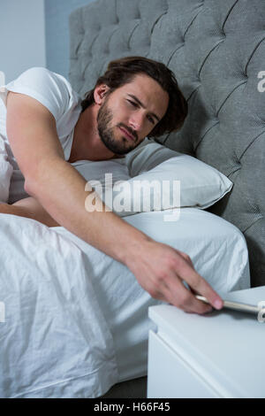 Uomo di svegliarvi con mobile sveglia Foto Stock