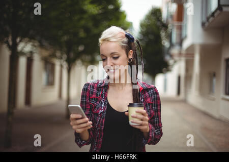 Donna che utilizza il cellulare mentre un caffè Foto Stock