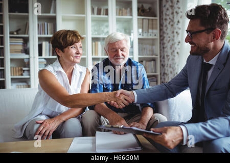 Advisor finanziario stringono le mani con i senior donna Foto Stock