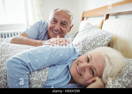 Felice coppia senior giacente sul letto Foto Stock