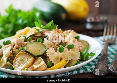 Pasta con le zucchine, pollo e piselli verdi. Foto Stock