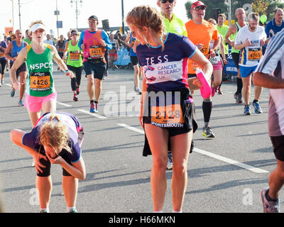 Un corridore vomita durante l'ultimo rettilineo della Great South Run Foto Stock