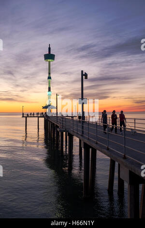 Le persone si godono una passeggiata al tramonto lungo il molo presso la spiaggia Brighton di Adelaide, Adelaide Australia Foto Stock
