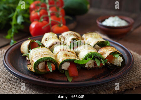 Rotoli di zucchine con formaggio, peperoni e rucola. Vista superiore Foto Stock