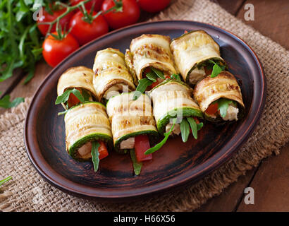 Rotoli di zucchine con formaggio, peperoni e rucola. Foto Stock