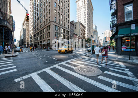 Scena di strada presso l'angolo di Broadway e E 21st Street, Flatiron Building con vista uptown, Manhattan New York City Foto Stock