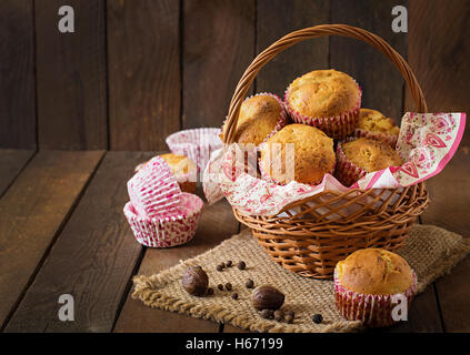 Muffin alla frutta con noce moscata e pepe della Giamaica in un cesto di vimini su un sfondo di legno. Foto Stock