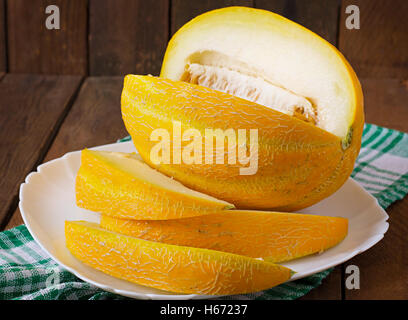 Il melone tagliato in pezzi su una piastra Foto Stock