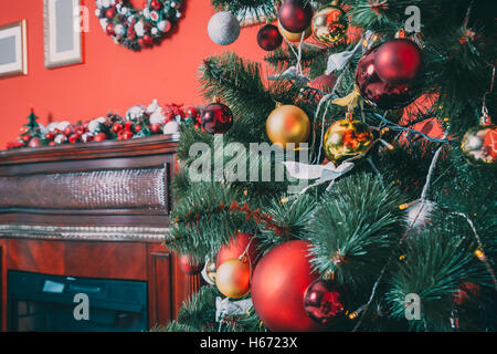 Bellissimo e nuovo anno camera con albero di Natale decorato e camino. L'idea per cartoline. soft focus. shallow dof Foto Stock