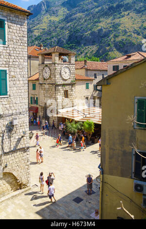 KOTOR, MONTENEGRO - Giugno 29, 2015: Scena della Piazza di Armi (Trg od Oruzja), e la torre dell orologio, con caffè, la gente del posto e turisti Foto Stock