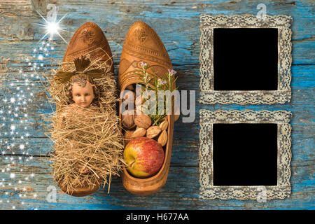 Il tempo di Natale due vintage photo frame, antichi Gesù Bambino e offerte sulla vecchia sullo sfondo di legno Foto Stock