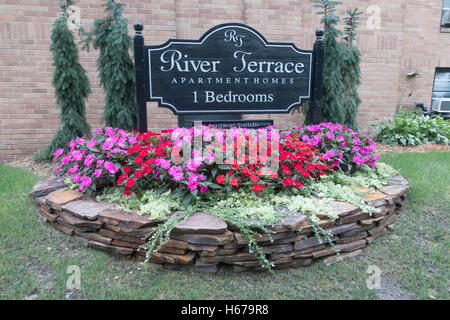 Terrazza sul fiume e affitto appartamento segno incastonata in un bellissimo giardino di rosso e viola begonia fiori. St Paul Minnesota MN USA Foto Stock