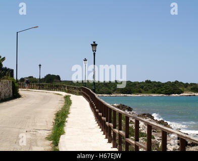 Strada tortuosa con orlo sovradimensionate all estremità orientale di San Spiridione Beach, Corfu Grecia Foto Stock