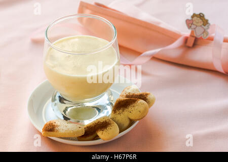 Zabaione, italiano dolce fatto di tuorli, lo zucchero e il vino Marsala servito con a forma di cuore i cookie Foto Stock