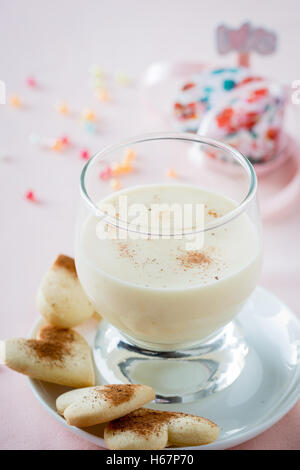 Zabaione, italiano dolce fatto di tuorli, lo zucchero e il vino Marsala servito con a forma di cuore i cookie Foto Stock