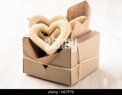 Confezione regalo riempito con cuore in casa i cookie per il giorno di san valentino su bianco tavolo in legno Foto Stock