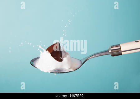 Splash ritratto del cucchiaio con cioccolato e latte Foto Stock