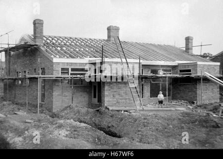 Giovane ragazzo in piedi davanti al bungalow in costruzione England Regno Unito degli anni sessanta Foto Stock