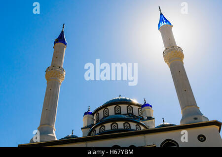 Sole dietro il minareto di una moschea Foto Stock