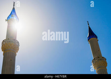 Sole dietro il minareto di una moschea Foto Stock