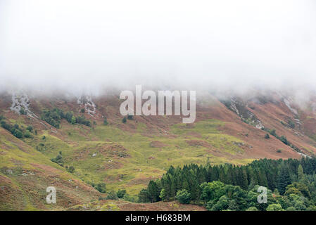 Cloud pioggia formando una fitta nebbia scendendo dal ripido pendio di Bidean nam Bian in Glen Coe, Argyll, Highlands scozzesi, Scozia Foto Stock