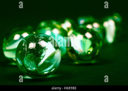 Close up di verde vintage retrò biglie di vetro isolato su sfondo nero Foto Stock
