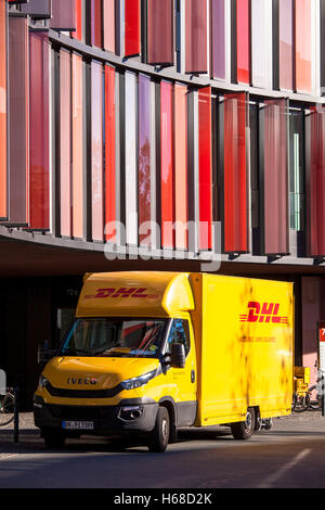 Germania, Colonia, DHL parcel service auto di fronte all'edificio degli uffici di Colonia uffici ovale. Foto Stock