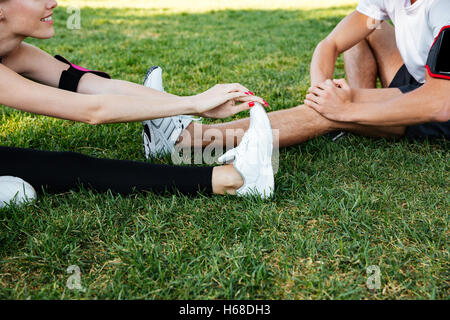Immagine ritagliata di un sportive uomo e donna facendo esercizi di stretching nel parco Foto Stock