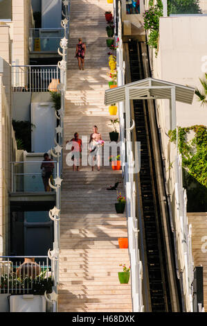 La gente camminare su e giù per una lunga serie di gradini esterni collegare i piani di un edificio. Foto Stock