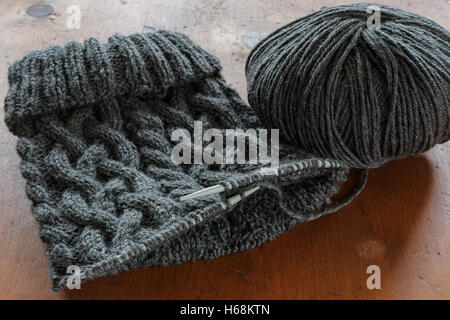 Il processo di lavorazione a maglia di un cappello con un cablaggio estensivo. Foto Stock