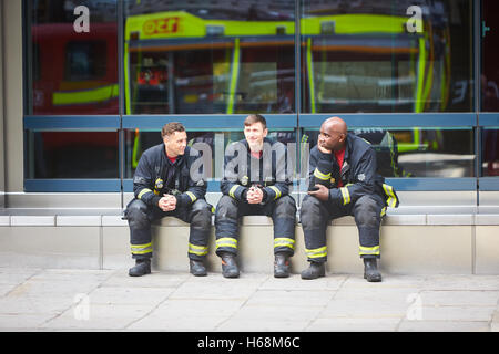 Vigili del fuoco si prendono una pausa dopo aver partecipato a un bus sul fuoco in Bishopsgate, London Foto Stock