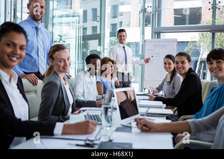 Imprenditore discutendo sulla lavagna bianca con i colleghi Foto Stock