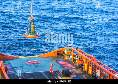 Offshore di lavoratore di essere trasferito alla barca personale utilizzando il trasferimento di cestello Foto Stock